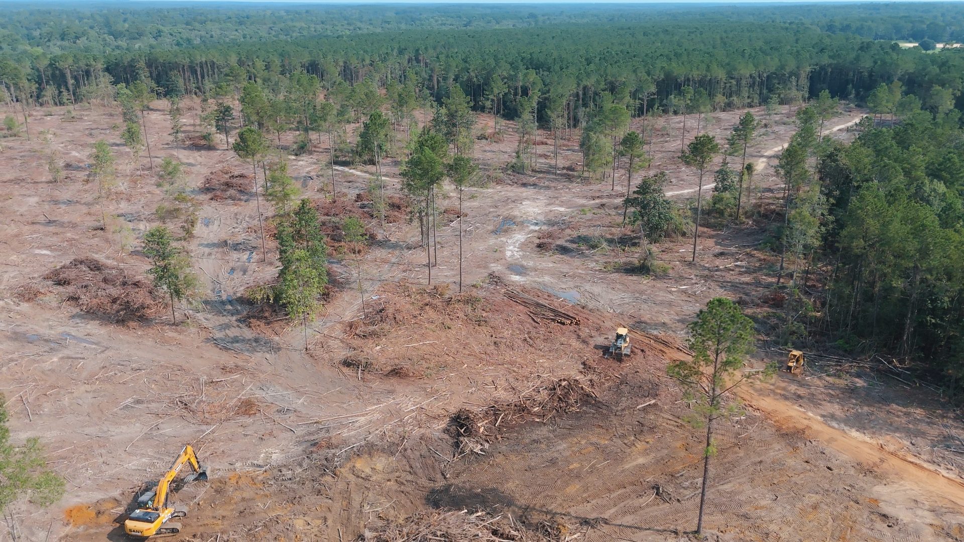 Aerial view of a lot cleared of timber with an excavator working the site