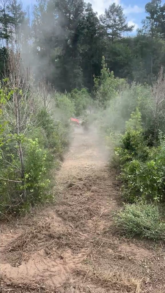 Mulcher throwing dust while clearing heavy brush